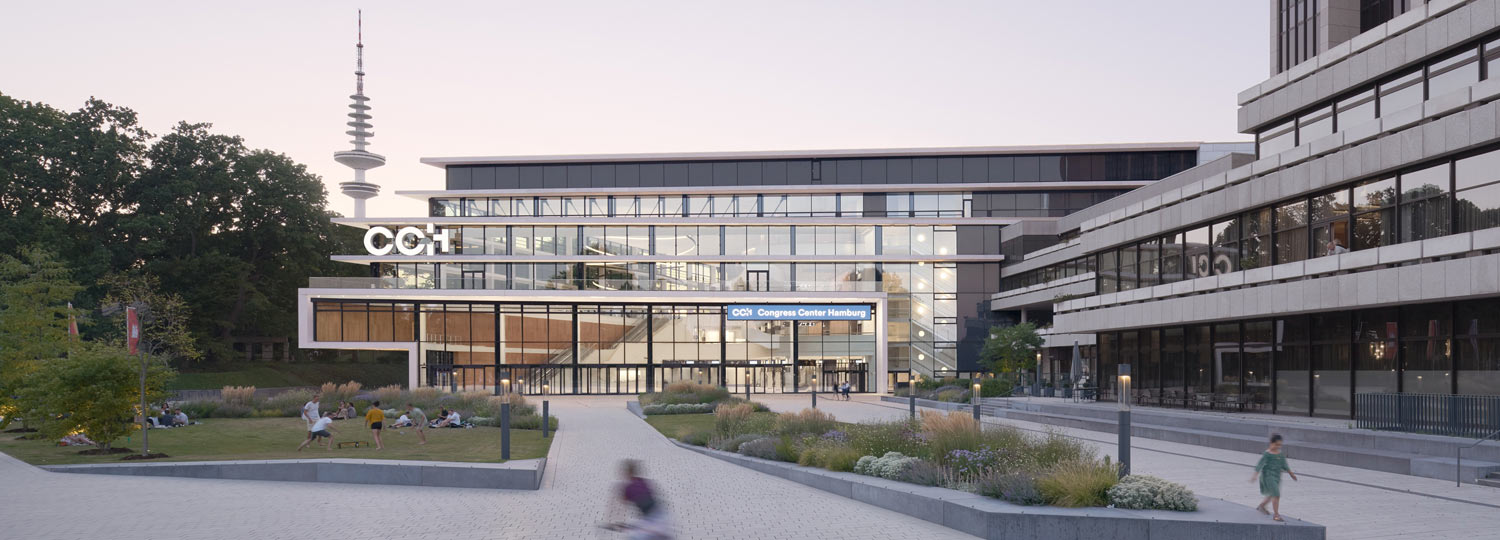 Modernes Kongresszentrum CCH Hamburg mit Glasfassade, Vorplatz und Menschen im Abendlicht