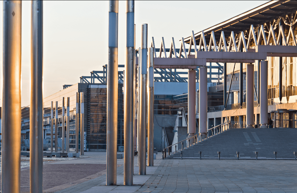Konferenzzentrum mit modernen Strukturen und Säulen im Vordergrund bei Sonnenuntergang